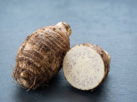 Taro root cut showing interior texture on dark surface