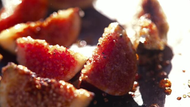 Grilled fig halves with sugar glistening on a dark metal grill