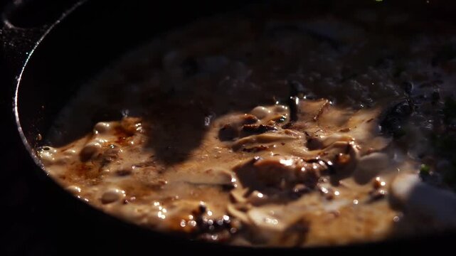 Creamy mushroom sauce with fresh parsley garnish in a dark pan