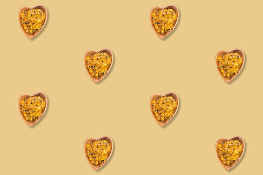 Heart shaped bowls of mango and passion fruit jam repeated across a golden background in a decorative dessert pattern