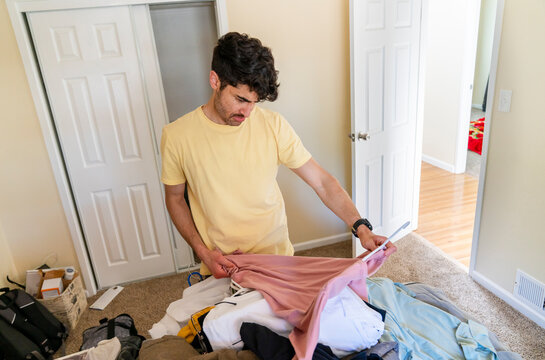 organizing laundry on bed hanger shirt