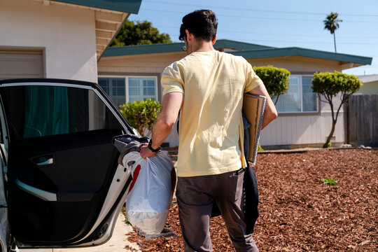 domestic lifestyle carrying stuff from car in driveway