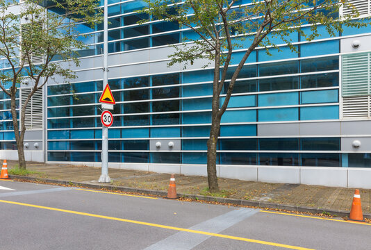 Modern Office Building Exterior View with Speed Limit Road Sign