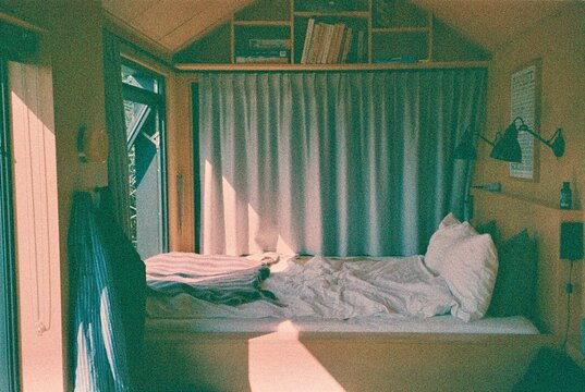 Sunlit Bed in a Cozy Wooden Cabin Interior