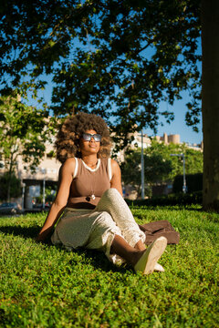 A woman is sitting and relaxing on the park grass