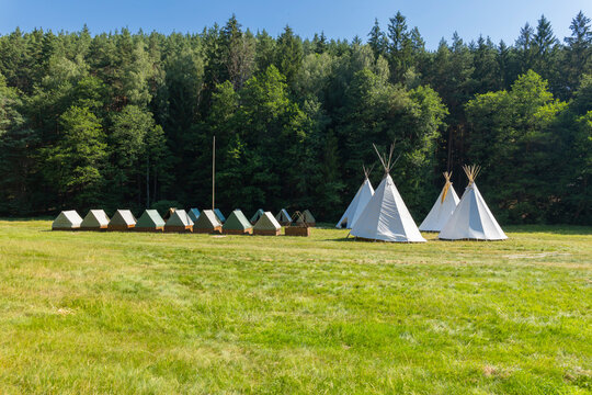 Summer camp with tipis and small tents in meadow