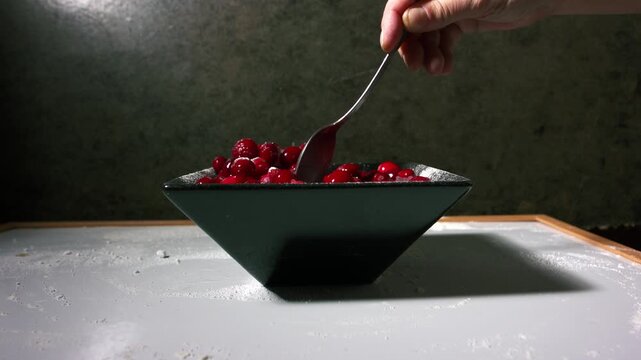 Hand stirring red ripe cranberries in a bowl