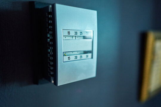 Vintage Analog Wall Thermostat on a Dark Blue Wall