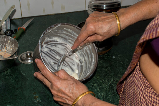 zero food waste at inidan kitchen, lady taking out food that is stick on vessel