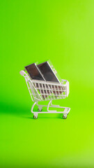 Side view of two fine silver bars in white shopping cart on green background for vertical social media.     © wibiwisnu
