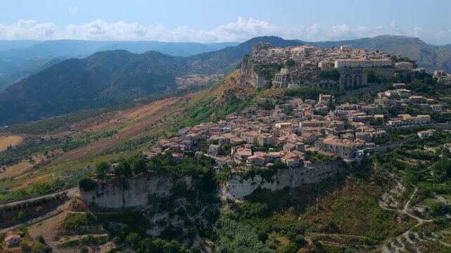 Gerace Calabria Italy 4k drone view of historic clifftop borgo village. One of most beautiful villages in Italy hidden gem perched on rocky cliff surrounded by mountains establishing shot