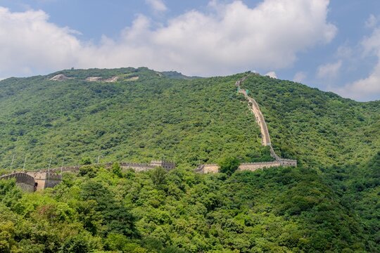 The Great Wall of China climbing steeply up a forested mountain at Mutianyu, Beijing