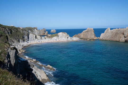 Aerial view of dramatic cliffs, sea stacks, and turquoise water along Costa Quebrada coastline, Cantabria, Northern Spain