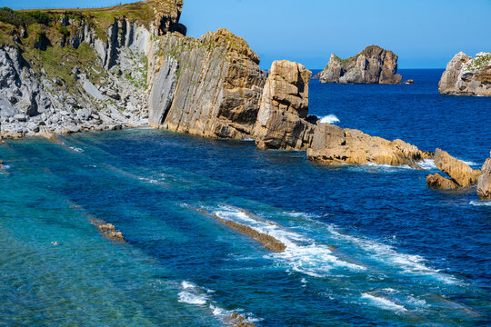 Aerial view of dramatic cliffs, sea stacks, and turquoise water along Costa Quebrada coastline, Cantabria, Northern Spain