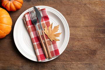Fototapeta premium Autumn table setting with pumpkins and maple leaf on wooden background