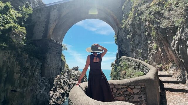 Fashion Woman in Hat Standing at Furore Fjord Bridge Amalfi Coast