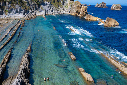 Aerial view of dramatic cliffs, sea stacks, and turquoise water along Costa Quebrada coastline, Cantabria, Northern Spain