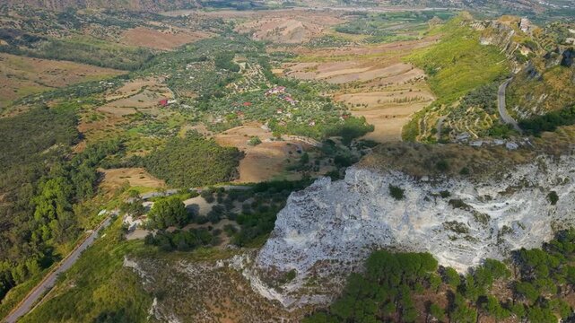 Gerace Calabria Italy 4k drone view of narrow cliff ridge tail. Flyover along sheer vertical rock spine revealing historic borgo hanging over abyss establishing shot. Unique places hidden gems