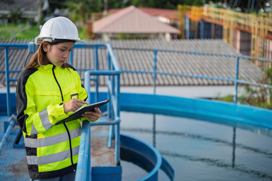 Water supply engineer reviews treatment basin conditions and piping while documenting field data for water quality monitoring, maintenance planning, and reliable water production.