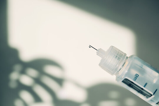 GLP-1 Syringe needle with small droplet of medicine ready for injection