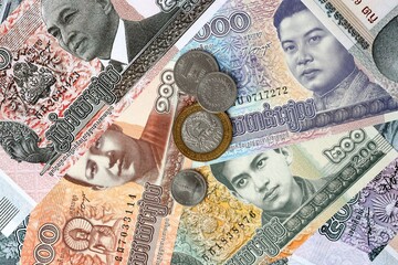 Cambodian riel money banknotes and coins on table. Cambodia cash bills of KHR currency © Viktor