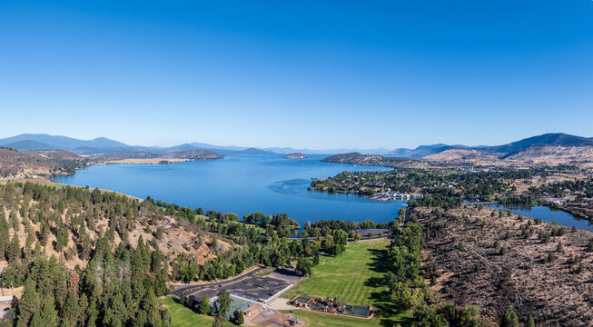 Drone perspective over forested hills toward Klamath Lake in Klamath Falls, Oregon, showcasing a vast water body.