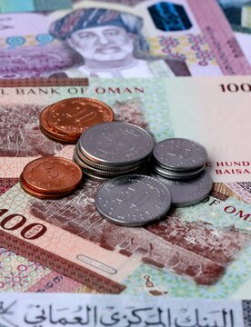 Omani rial money notes and coins on table. Oman cash bills of OMR currency close up