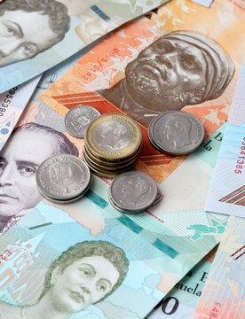 Venezuelan bolivar money notes and coins on table. Venezuela cash bills of VES currency close up