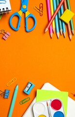 Flat lay with notebook and school stationery on orange background, copy space © Sunlight