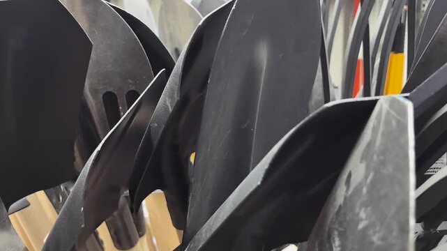 A collection of sturdy shovels and pitchforks stands ready, showcasing their sleek tools in a well-organized setting. They await the hands of eager workers in a farm or garden environment.