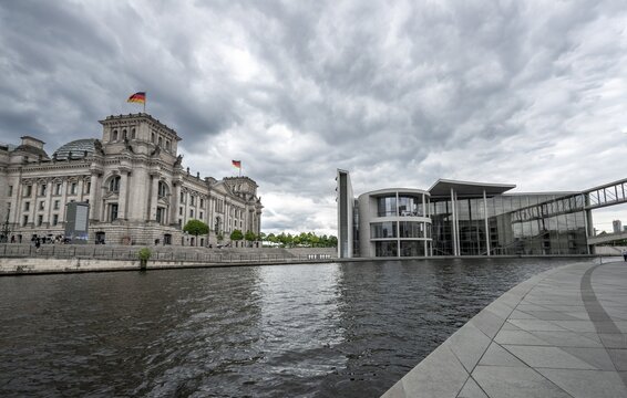 Reichstag building with waving German flag and Paul L&ouml;be House on the Spree, government district, Berlin, Germany