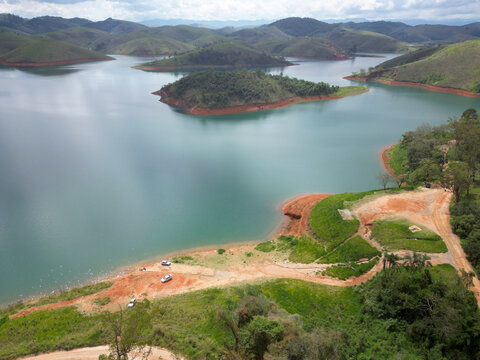 Visto de cima com drone represa cheia e bonita com paisagens ao fundo de montanhas.