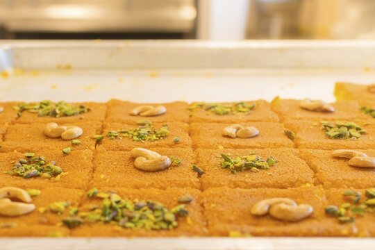 Close up fresh kunafa dessert sliced servings. Specialized street sweets shop food preparation