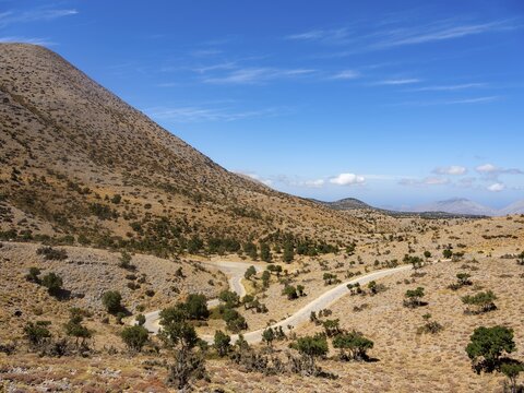 Narrow road winds through karst mountain landscape at Psiloritis, Ida Massif, Crete, Greece