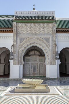 A richly decorated Islamic building with a central well, surrounded by mosaics and Islamic architectural elements