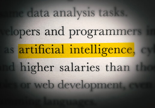 Close up of printed text with highlighted phrase artificial intelligence on paper background design concept for technology