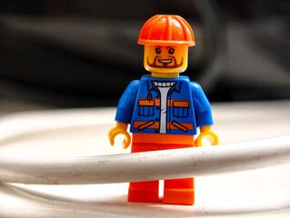Naklejka premium Russia, St. Petersburg, August 8, 2020 A close-up shot of a Lego man with an orange helmet, perfect for illustration or design projects
