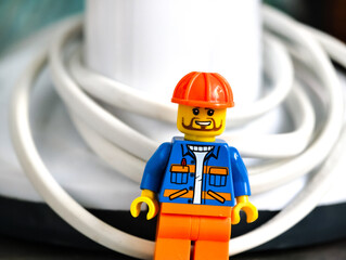 Naklejka premium Russia, St. Petersburg, August 8, 2020 A lego figurine wearing an orange helmet and blue jacket, ideal for illustrations or decorations