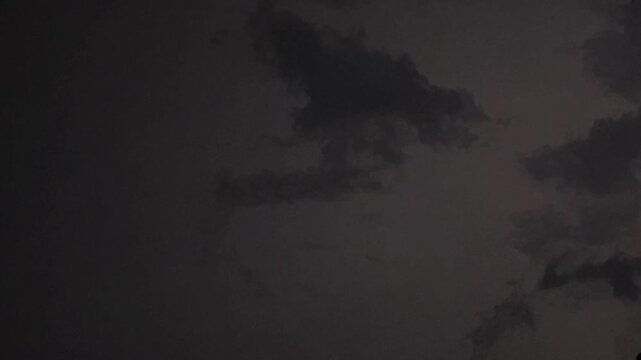 Dark storm clouds and lightning strike during thunderstorm in night sky 4k footage weather background