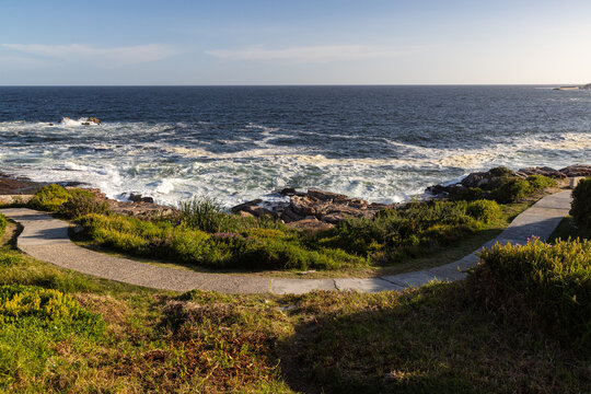 large pounding waves and spray hitting rocky cliffs of Hermanus South African coastline