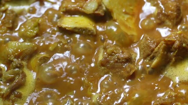 Closeup of a delicious spicy mutton curry cooking in a pan, traditional indian meat dish with rich gravy and aromatic spices