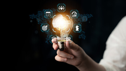 A creative representation of business innovation featuring a glowing light bulb in hand with digital icons highlighting themes of growth and strategy in the modern economy. Nascent © InfiniteFlow