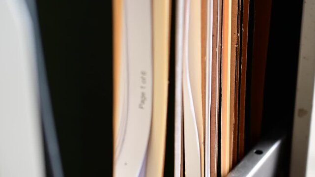 Cinematic bokeh b roll video of file cabinet opening panning moving files, office work searching theme