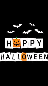 Orange pumpkin jack-o'-lantern with white paper letters spelling Happy Halloween and flying bats