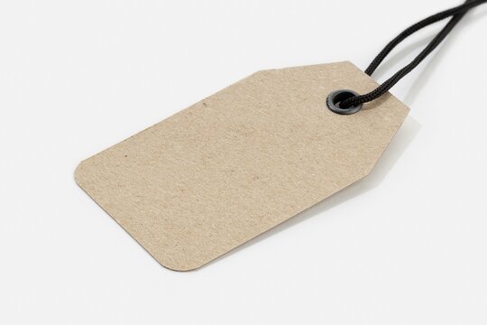 Single blank textured beige tag with black string on white background