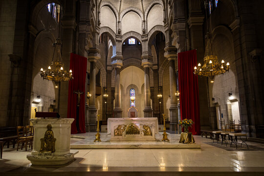 Grand nave interior of Cathedrale Saint Charles Borromee reveals gothic columns and golden chandeliers. Historic French church architecture concept highlights spiritual heritage in Saint Etienne.