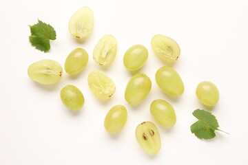 Naklejka premium Fresh ripe grapes and green leaves on white background, flat lay
