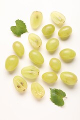 Fototapeta premium Fresh ripe grapes and green leaves on white background, flat lay