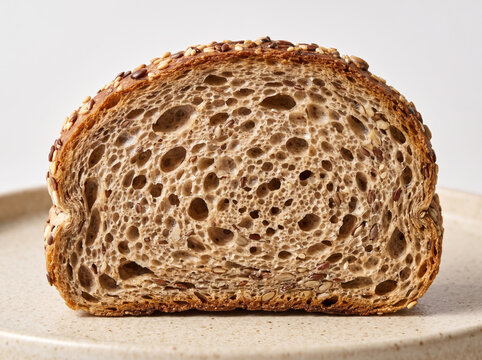 Sliced loaf of multigrain sourdough bread showing airy crumb and seeded crust