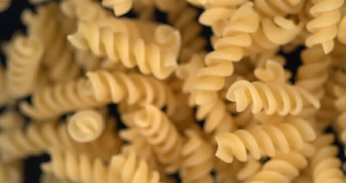 Fusilli pasta falling in slow motion 1000 fps on black background
